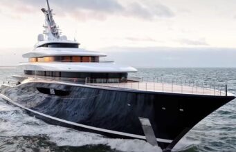 Travel Experts Reveal Amazing Benefits of Upholstery for Boat Interiors Large luxury motor yacht with a dark hull cruises the open sea at sunset, multi-deck white superstructure visible.