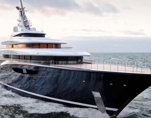 Travel Experts Reveal Amazing Benefits of Upholstery for Boat Interiors Large luxury motor yacht with a dark hull cruises the open sea at sunset, multi-deck white superstructure visible.