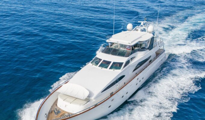 Amazing Benefits of Reupholstering a Boat Every Owner Should Know White luxury motor yacht cruising through deep blue ocean, creating a frothy wake.